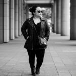 Stylish petite woman in a fashionable outfit emphasizing vertical lines and monochrome colors