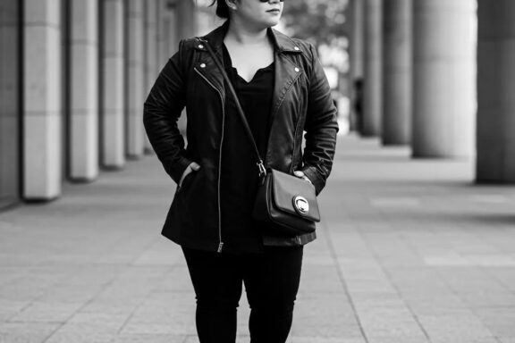 Stylish petite woman in a fashionable outfit emphasizing vertical lines and monochrome colors